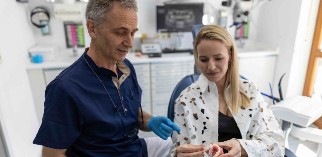 Zahnarzt zeigt Patientin Invisalign Schiene